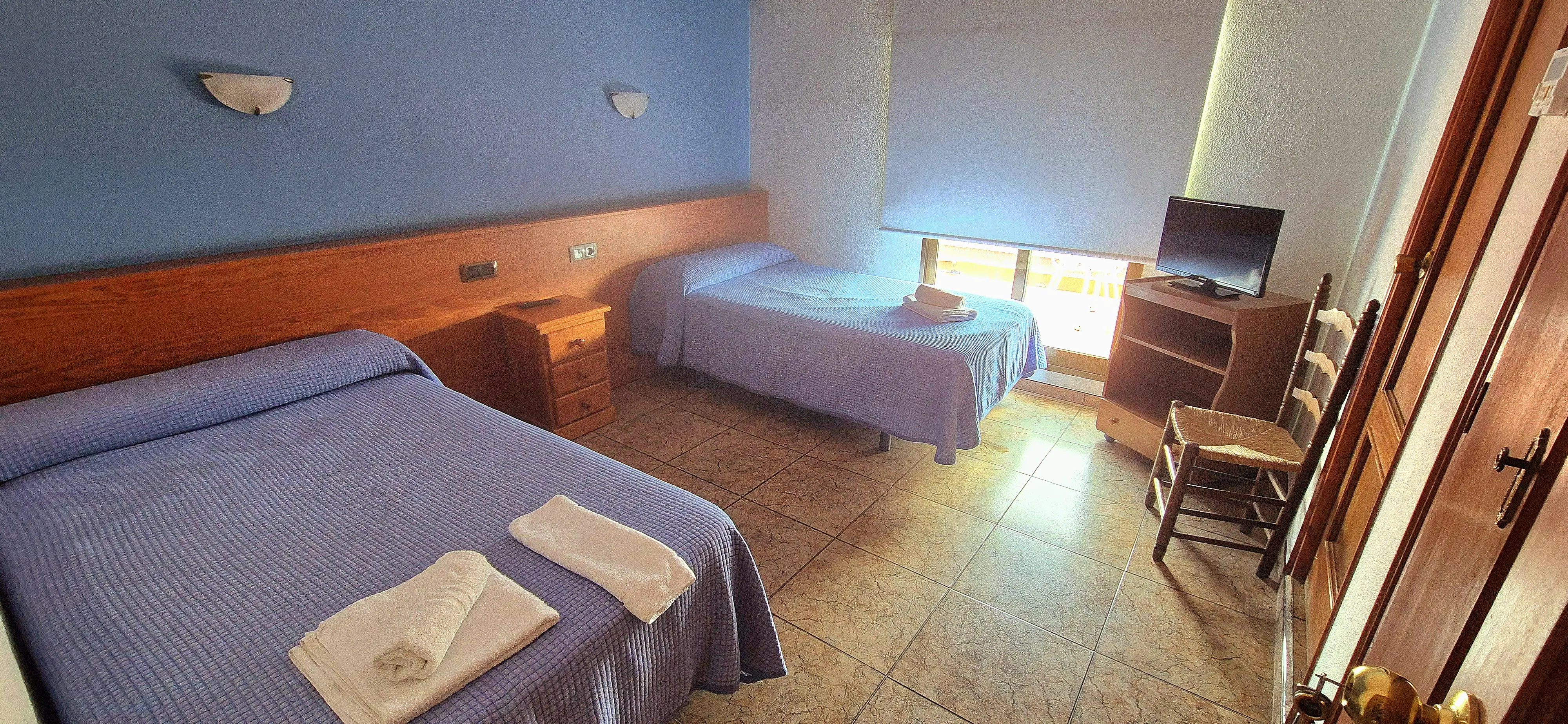 Habitación doble moderna con camas gemelas y colchas azules